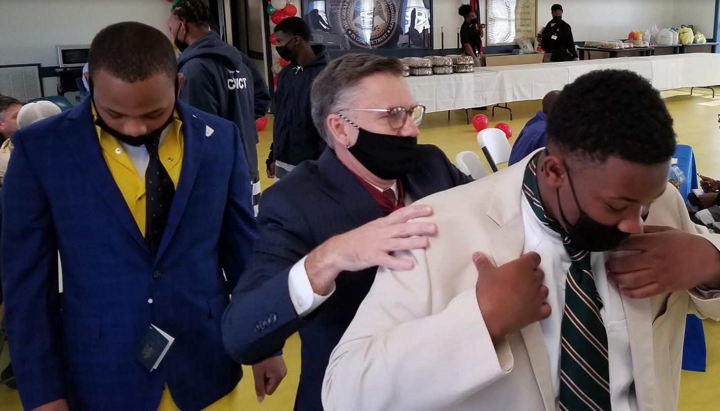 Stan Jones, center, assists MDOC inmate Jonathan Taylor, right, with fitting a dress coat while fellow inmate William Hayes, left, enjoys the look and feel of a coat and tie during a mental health resources fair held this week at the Youth Offender Unit of the Central Mississippi Correctional Facility.