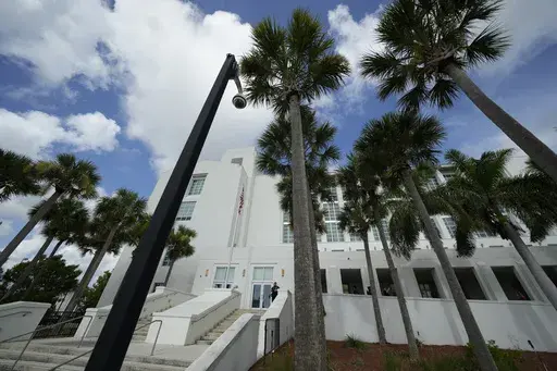 A police officer stands beside an entrance to the Alto Lee Adams Sr. U.S. Courthouse, Aug. 15, 2023, in Fort Pierce, Fla. The federal judge presiding over the classified documents case against former President Donald Trump is hearing arguments Friday, June 21, 2024, on a long-shot defense effort to get the indictment thrown out based on the claim that the prosecutor who brought the charges was illegally appointed. (AP Photo/Rebecca Blackwell, File)