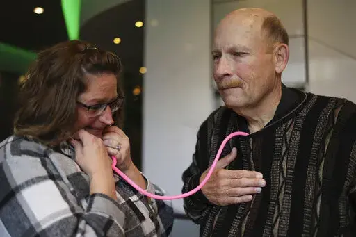 Amber Morgan, from South Bend, Ind., listens to the heartbeat of Tom Johnson, from Kankakee, at Travelodge by Wyndham Downtown Chicago, on Saturday, Nov. 19, 2022, in Chicago. Morgan and Johnson met for the first time Saturday, four years after he received a heart transplanted from the body of Morgan's daughter, Andreona Williams, who was 20 when she died from asthma complications. “It’s almost like I got to hug my daughter again,” Morgan said. (Michael Blackshire/Chicago Tribune via AP)