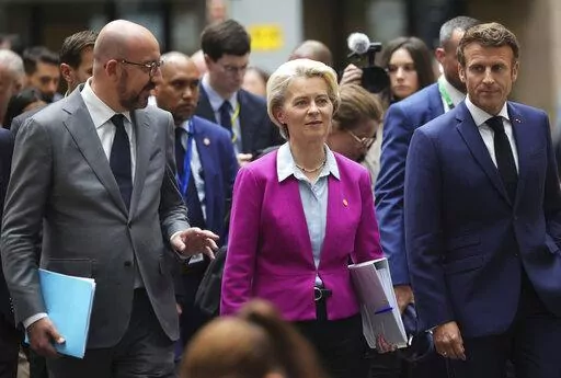 European Council President Charles Michel, left, European Commission President Ursula von der Leyen, center, and French President Emmanuel Macron, right, walk though the press room prior to a media conference at an EU summit in Brussels, Friday, June 24, 2022. EU leaders discussed economic topics at their summit in Brussels Friday amid inflation, high energy prices and a cost of living crisis. (AP Photo/Olivier Matthys)