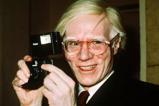 In this 1976 file photo, pop artist Andy Warhol smiles in New York. The Supreme Court on Thursday, May 18, 2023, sided with a photographer who claimed the late Andy Warhol had violated her copyright on a photograph of the singer Prince. The Supreme Court sided 7-2 with photographer Lynn Goldsmith. The case involved images Warhol created of Prince as part of a 1984 commission for Vanity Fair. Warhol used a Goldsmith photograph as his starting point. (AP Photo/Richard Drew, File)