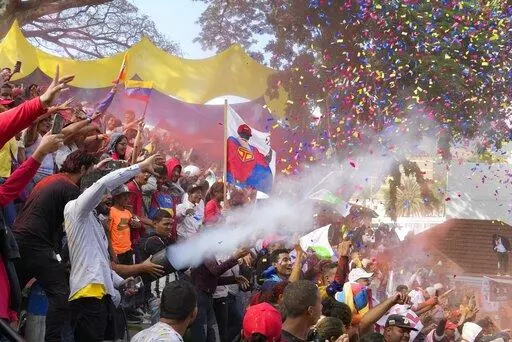 A banner of President Nicolás Maduro depicted as a superhero is held amid supporters as they are showered in confetti during an event marking Youth Day at the Miraflores Presidential Palace in Caracas, Venezuela, Sunday, Feb. 12, 2023. A generation of children in Venezuela have only known a country in crisis, plagued over the last decade or more by shortages and inflation. They have also known only one president, Nicolás Maduro. He took over when his mentor Hugo Chávez died of cancer a decade