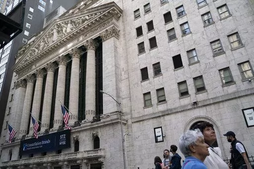 Pedestrians pass the New York Stock Exchange, Thursday, May 5, 2022, in the Manhattan borough of New York.  Stocks are opening lower and bond yields are rising as yet another report of robust hiring suggests the Federal Reserve will need to keep pressing the fight against inflation and cool off the economy with higher interest rates.  (AP Photo/John Minchillo)