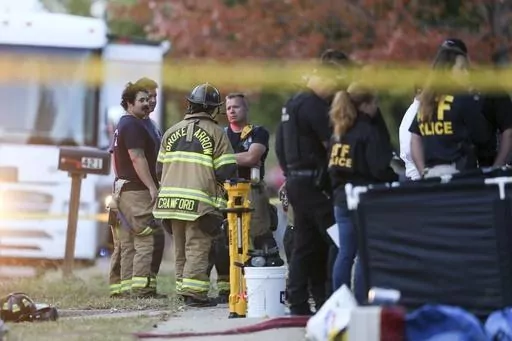 Police and firefighters investigate the scene of a house fire with multiple fatalities in Broken Arrow, Okla., outside Tulsa, Oct. 27, 2022. Eight people were found dead after the fire was extinguished and police said they were investigating the deaths as homicides. Preliminary autopsy reports show eight members of a Broken Arrow family found dead inside their burning home were each shot. The bodies of Brian Nelson, 34, his wife Brittney Nelson, 32, and their six children were found in October 2