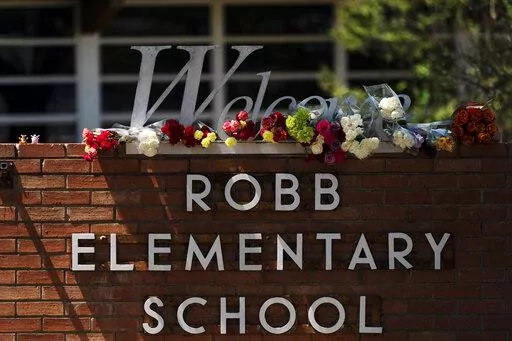 Flowers are placed around a welcome sign outside Robb Elementary School in Uvalde, Texas, Wednesday, May 25, 2022, to honor the victims killed in a shooting at the school a day earlier. In the aftermath of the elementary school massacre in Uvalde, Texas, schools around the U.S. have brought in additional security staff and restricted visitors as they've dealt with a new rash of copycat threats. (AP Photo/Jae C. Hong, File)