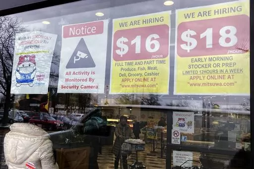 Hiring signs are displayed at a grocery store in Arlington Heights, Ill., Jan. 13, 2023. Employers are increasingly posting salary ranges for job openings, even in states where it's not mandated by law, according to analysts with employment sites Indeed, GlassDoor, and Monster. (AP Photo/Nam Y. Huh, File)