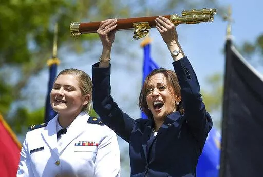 Vice President Kamala Harris lifts the school scepter at the conclusion of the U.S. Coast Guard Academy's 141st Commencement Exercises Wednesday, May 18, 2022 in New London, Conn. At left is Carolyn Ziegler, the last cadet of the 250 to graduate.  (AP Photo/Stephen Dunn)