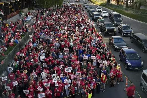 Members of the Culinary Workers Union rally along the Las Vegas Strip, Thursday, Aug. 10, 2023, in Las Vegas. After a marathon week of negotiations, the Las Vegas hotel workers union says it has reached a tentative deal with Wynn Resorts. It was the last contract the Culinary Workers Union needed to avoid a strike Friday, Nov. 10, 2023, and came after the union's tentative deals with Caesars Entertainment and MGM Resorts. (AP Photo/John Locher, File)