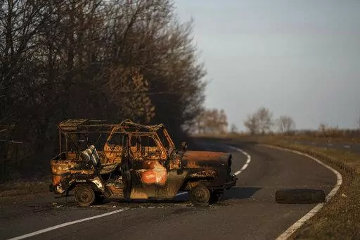 A burned Ukranian army vehicle stands on a street leading to the airport of the city of Mykolaiv, Ukraine, Friday, 25, 2022.(AP Photo/Petros Giannakouris)