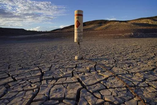 A buoy sits high and dry on cracked earth previously under the waters of Lake Mead at the Lake Mead National Recreation Area near Boulder City, Nev., on June 28, 2022. Living with less water in the U.S. Southwest is the focus for a conference starting Wednesday, Dec. 14, 2022, in Las Vegas, about the drought-stricken and overpromised Colorado River. (AP Photo/John Locher, File)