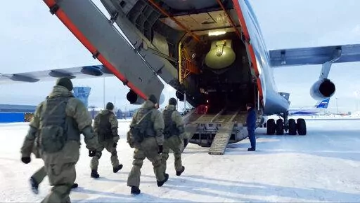 In this photo taken from video released by the Russian Defense Ministry Press Service, Russian peacekeepers board on a Russian military plane at an airfield outside Moscow, in Russia to fly to Kazakhstan Thursday, Jan. 6, 2022. A Russia-led military alliance, the Collective Security Treaty Organization, said early Thursday that it would send peacekeeper troops to Kazakhstan at the request of President Kassym-Jomart Tokayev. (Russian Defense Ministry Press Service via AP)