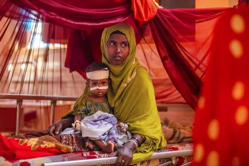 Mother Ayan Muhammed sits with her severely-malnourished baby boy Fahir, as he receives life-saving nutritional treatment, at a UNICEF-supported stabilization center at Gode Hospital in the Shabelle Zone of the Somali region of Ethiopia Tuesday, April 12, 2022. Agricultural workers in the east and Horn of Africa are preparing for their most severe drought in forty years, as authorities warn that higher temperatures and less than normal rainfall were recorded by weather agencies in March and Apri