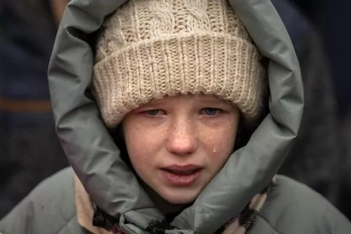 Anna, 10, cries next to the body of her brother Yurii, 27, during his funeral in Kalynivka, near Kyiv, Ukraine, Tuesday, Feb. 21, 2023. Yurii Kulyk, a civilian who was a volunteer in the armed forces of Ukraine, was killed during a rocket attack on Feb.15 in Lyman, a city in the Donetsk region of Ukraine. (AP Photo/Emilio Morenatti)