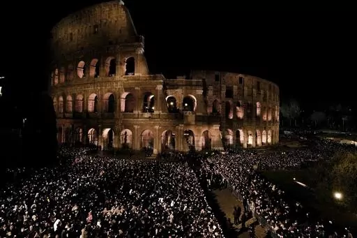People hold candles during a Via Crucis (Way of the Cross) torchlight procession on Good Friday, in Rome, Friday, April 7, 2023. The Vatican says Pope Francis won't go to the Colosseum for the traditional Good Friday procession but instead he will watch it from his home at the Vatican due to unseasonably cold nighttime temperatures in Rome. (AP Photo/Alessandra Tarantino)
