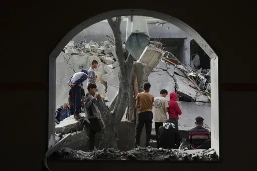 Palestinians inspect the site hit by an Israeli strike in Deir al-Balah, Gaza Strip on Monday, April 7, 2025. (AP Photo/Abdel Kareem Hana)