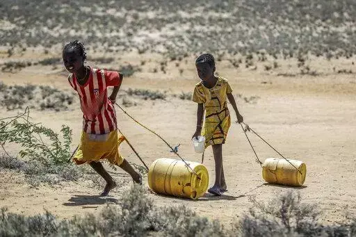 Young girls pull containers of water during a drought as they return to their huts from a well in the village of Lomoputh in northern Kenya on, May 12, 2022. Better climate-related research and early weather warning systems are needed as extreme weather — from cyclones to drought — continues to inflict the African continent, said the Sudanese billionaire and philanthropist Mo Ibrahim, who heads up his own foundation. (AP Photo/Brian Inganga, File)