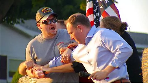 In this image taken from video provided by WHEC-TV, David Jakubonis, left, is subdued as he brandishes a sharp object during an attack U.S. Rep. Lee Zeldin, right, as the Republican candidate for New York governor delivered a speech in Perinton, N.Y., Thursday, July 21, 2022. Jakubonis, 43, has been charged with attempted assault, arraigned and released, a Monroe County sheriff's spokesperson said. (WHEC-TV via AP)