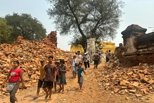 Visitors walk near entrance of Maha Aungmye Bonzan Monastery, commonly known as the Me Nu Brick Monastery, in the aftermath of Friday's earthquake in Innwa, Tada-U township, Mandalay, Myanmar, Friday, April 4, 2025. (AP Photo)