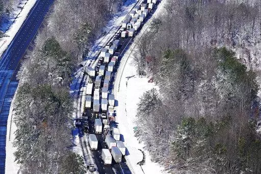 Drivers wait for the traffic to be cleared as cars and trucks are stranded on sections of Interstate 95 Tuesday Jan. 4, 2022, in Carmel Church, Va. Close to 48 miles of the Interstate was closed due to ice and snow. (AP Photo/Steve Helber)