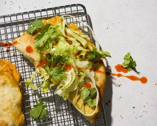 This image released by Milk Street shows a recipe for oven-fried potato and cheese tacos dorados. (Milk Street via AP)