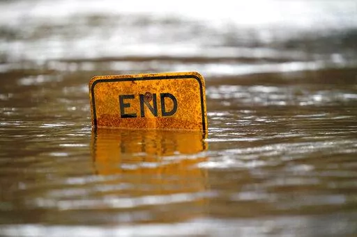A boat ramp sign is submerged in the Tar River as it rises following a heavy rain in Princeville, N.C., Thursday, March 17, 2022. The river continues to be a threat to the small community nestled in the flood plain of the Tar River. (AP Photo/Gerry Broome)