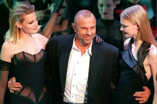 French fashion designer Thierry Mugler on the catwalk with unidentified models after the presentation of his 1998-99 fall-winter ready-to-wear collection presented in Paris on March 15, 1998. French fashion designer Thierry Mugler, whose dramatic designs were worn by celebrities like Madonna, Lady Gaga and Cardi B, has died. He was 73. A post all in black on his official Instagram account said he died Sunday, Jan. 23, 2022 and “May his soul Rest In Peace." It did not give a cause of death. (AP