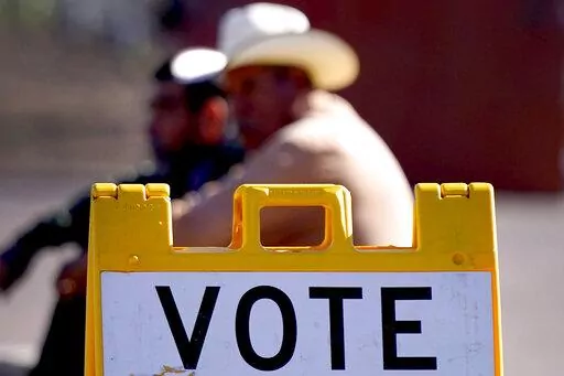 Guadalupe residents sit outside a polling station, Tuesday, Nov. 8, 2022, in Guadalupe, Ariz. (AP Photo/Matt York)