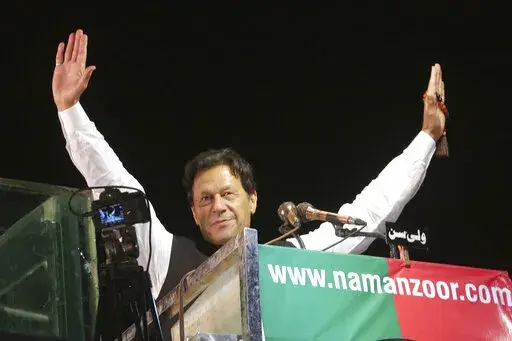 Former Pakistani Prime Minister Imran Khan waves to his supporters during an anti government rally, in Lahore, Pakistan, April 21, 2022. Pakistani police have filed terrorism charges against Khan, authorities said Monday, Aug. 22, 2022, escalating political tensions in the country as he holds mass rallies seeking to return to office. (AP Photo/K.M. Chaudary, File)