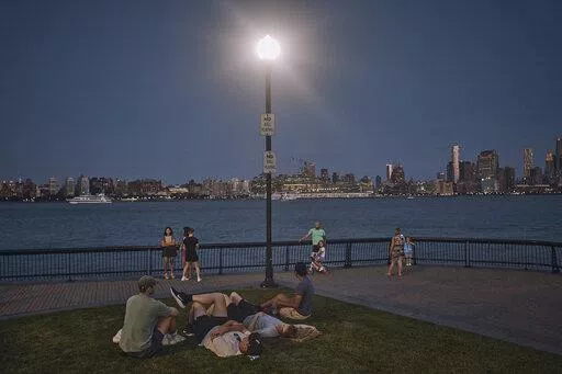 People spend time at the park at dusk during a summer heat wave, July 21, 2022, in Hoboken, N.J. The continental United States in July set a record for overnight warmth, providing little relief from the day’s sizzling heat for people, animals, plants and the electric grid, meteorologists said. (AP Photo/Andres Kudacki, File)