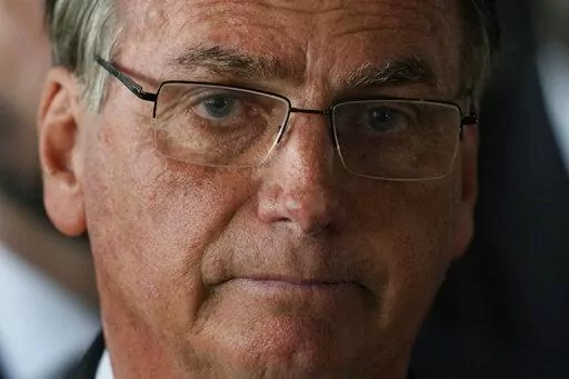 Brazilian President Jair Bolsonaro looks on after speaking from his official residence the Alvorada Palace in Brasilia, Brazil, Nov. 1, 2022. His absence on Inauguration Day will mark a break with tradition and remains unclear who, instead of him, will hand over the presidential sash to Brazilian President-elect Luiz Inacio Lula da Silva at the presidential palace on Jan. 1, 2023. (AP Photo/Eraldo Peres, File)