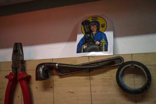 A sticker with the image known as "Saint Javelin" depicting a saint holding a Javelin, an American-made portable anti-tank missile system, is displayed in an artists co-living studio space that is used as a bomb shelter and a place to help the Territorial Defense Units, in Kyiv, Ukraine, Wednesday, March 23, 2022. (AP Photo/Rodrigo Abd)