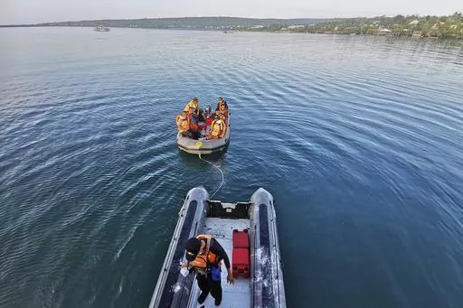In this photo provided by the National Search and Rescue Agency (BASARNAS), rescuers on a rubber boat search for survivors after an overloaded ferry sank off Sulawesi Island, Indonesia, Monday, July 24, 2023. (BASARNAS via AP)