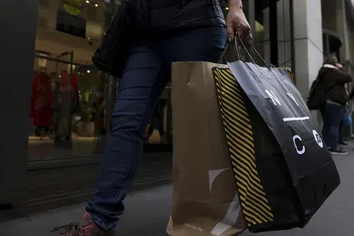 A shopper carries bags down Fifth Avenue on Friday, Nov. 25, 2022, in New York. (AP Photo/Julia Nikhinson, File)
