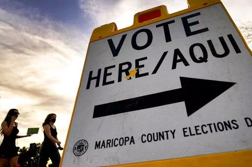 In this Nov. 3, 2020, file photo, voters deliver their ballot to a polling station in Tempe, Ariz. A review of potential voter fraud cases in the 2020 general election in Arizona's second-largest county ended, Friday, Jan. 14, 2022, with an announcement by prosecutors that none of the 151 cases they reviewed merited criminal charges. The findings in Pima County provide yet another official rebuttal to former President Donald Trump's claims that voter fraud led to his loss in Arizona and other ba