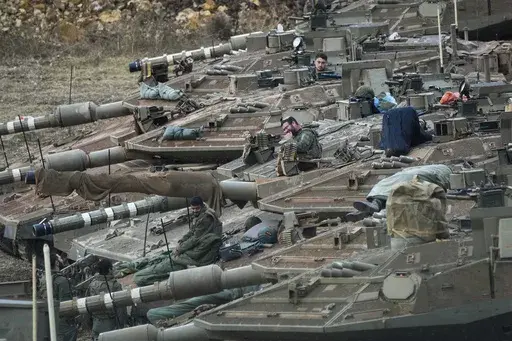 Israeli soldiers work on tanks in a staging area in northern Israel near the Israel-Lebanon border, on Oct. 1, 2024. (AP Photo/Baz Ratner, File)
