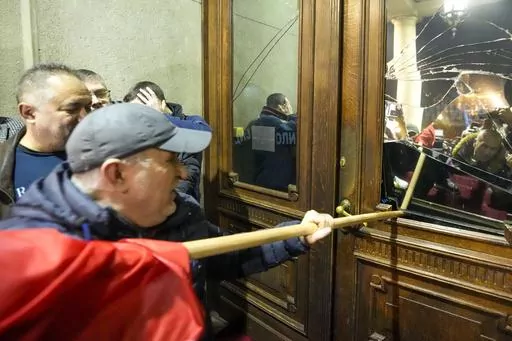 Opposition supporters attempt to enter the capital's city council building in protest of what election observers said were widespread vote irregularities during a general election last weekend in Belgrade, Serbia, Sunday, Dec. 24, 2023. The country's populist authorities have denied rigging the vote. President Aleksandar Vucic said Sunday that those claims were blatant "lies" promoted by the political opposition. (AP Photo/Darko Vojinovic)