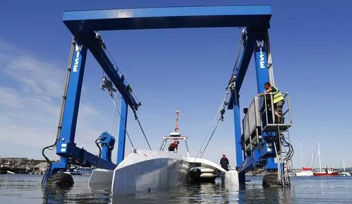 Technicians lower the Mayflower Autonomous Ship into the water at its launch site on Sept. 14, 2020, for its first outing on water since being built in Turnchapel, Plymouth south west England. The sleek autonomous trimaran docked in Halifax, Nova Scotia on Sunday, June 5, 2022, after more than five weeks crossing the Atlantic Ocean from England, according to tech company IBM, which helped build it. (AP Photo/Alastair Grant, File)