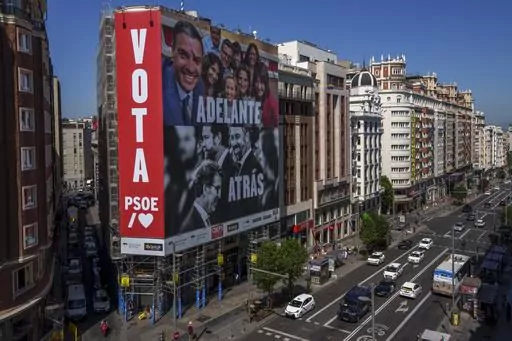 A giant electoral poster depicting Spain's Prime Minister and Socialist candidate Pedro Sánchez, top, and conservative PP party leader Alberto Nunez Feijóo and VOX far-right party leader Santiago Abascal is displayed on a building at the Gran Via avenue in Madrid, Spain, Monday, July 10, 2023. A general election on Sunday July 23, 2023, could make Spain the latest European Union member to swing to the right. Prime Minister Pedro Sánchez called the early election after his Spanish Socialist Wo