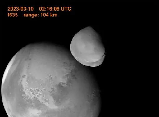 This image provided by the UAE Space Agency shows the planet Mars and its moon, Deimos, in the foreground. The United Arab Emirates’ Amal spacecraft - Arabic for Hope - flew within 62 miles of Deimos in March 2023. (UAE Space Agency via AP)
