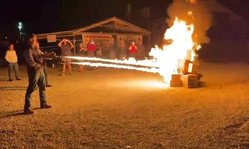 In this frame grab from video provided by Debbie McFarland, state Sen. Bill Eigel torches a pile of cardboard boxes at a “Freedom Fest” event in Defiance, Mo., Sept. 15, 2023. Eigel is a Republican candidate for Missouri governor. After video of Eigel's use of the flamethrower gained attention, Eigel said he'd burn objectionable books if that's what it took to keep them away from children. (Debbie McFarland via AP)