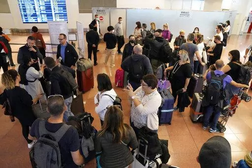 Foreign travelers gather upon arrival at the Haneda International Airport Tuesday, Oct. 11, 2022, in Tokyo. Japan's strict border restrictions are eased, allowing tourists to easily enter for the first time since the start of the COVID-19 pandemic. Independent tourists are again welcomed, not just those traveling with authorized groups. (AP Photo/Eugene Hoshiko)