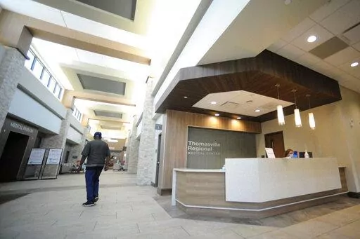 A man walks through the lobby of Thomasville Regional Medical Center in Thomasville, Ala., on Tuesday, May 3, 2022. The hospital is among three in the nation that say they are missing out on federal pandemic relief money because they opened during or shortly before the COVID-19 crisis began. (AP Photo/Jay Reeves)