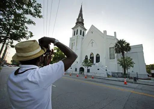 FILE _ This file photo shows Ausar Vandross taking a photo of Mother Emanuel AME Church in Charleston, S.C., on Thursday, June 16, 2016. The church is among those that have been assisted by a fund to help historic Black churches, and a new, $20 million donation will help additional ones. (AP Photo/Chuck Burton)