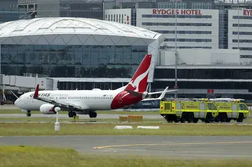 A Qantas jet is parked on the tarmac next to firetrucks at Sydney International Airport after making an emergency landing in Sydney, Wednesday, Jan. 18, 2023. The Qantas flight traveling from New Zealand to Sydney landed safely after it issued a mayday call over the Pacific Ocean. (Jeremy Ng/AAP Image via AP)