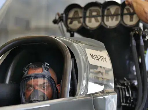 Tony Schumacher stares out from the seat of his Top Fule dragster while his crew runs tests prior to his first qualifying run of the Menards NHRA Heartland Nationals drag races Friday, May 18, 2018, at Heartland Motorsports Park in Topeka, Kan. Schumacher has a standard answer ready when drag racing fans ask when the 54-year-old three-time world champion plans to retire. Schumacher gives them the response he's used much of the past two decades: “About another 10 years.” (Chris Neal/The Capit