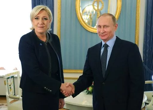 Russian President Vladimir Putin, right, shakes hands with French far-right presidential candidate Marine Le Pen, in the Kremlin in Moscow, Russia, Friday, March 24, 2017. France is thousands of miles from Ukraine, but what happens in French voting stations this month could have repercussions in Ukrainian battlefields. Nationalist candidate Marine Le Pen wants to halt arms supplies to Ukraine, improve Western ties with Russia and weaken the EU and NATO, which would undermine long-held Western al