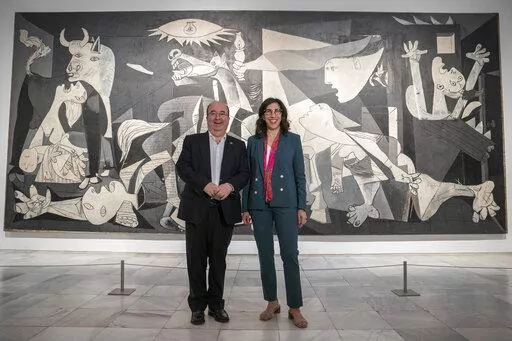 French Culture Minister Rima Abdul-Malakin, right, poses for a picture next to his Spanish counterpart Miquel Iceta during a joint news conference in front of Pablo Picasso's "Guernica" painting to present the "Picasso Year" events, marking the 50th anniversary of the painter's death, at the Reina Sofia Museum in Madrid, Spain, Monday, Sept. 12, 2022. Against the backdrop of Picasso's iconic anti-war painting, "Guernica," the culture ministers of France and Spain have gathered in Madrid to kick 