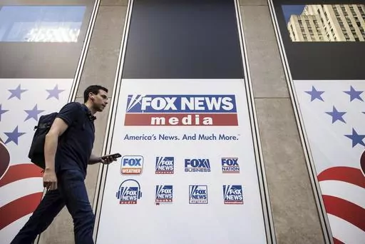 A person walks past the Fox News Headquarters in New York on April 12, 2023. Fox News will pay one of its former producers $12 million to settle her claims that she faced a discriminatory workplace and that the network tried to coerce her into giving false testimony in Dominion Inc.’s defamation lawsuit against the network, her lawyer said Friday, June 30, 2023. (AP Photo/Yuki Iwamura, File)