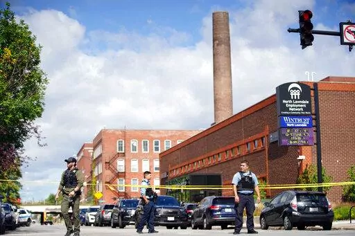 Officers set up crime tape outside a Chicago Police Department building in Homan Square, in Chicago, Monday, Sept. 26, 2022, where a person was shot by police. Chicago's police chief says a man used a fire escape  to infiltrate a police facility where officers were undergoing a SWAT training exercise and grabbed at least two guns before he was shot and wounded by police. (Anthony Vazquez/Chicago Sun-Times via AP)