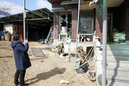 Local resident Park Sung-sook reacts at her damaged house near a bomb accident site in Pocheon, South Korea, Thursday, March 6, 2025. (AP Photo/Lee Jin-man)